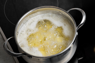 Potato wedges cooked in a pot on an induction stove. Cooking at home