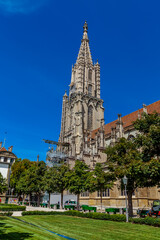 Fototapeta na wymiar BERN, SWITZERLAND - August 2nd 2022: Spire Bernese Cathedral (Berner Münster). View from the Münsterplatform.