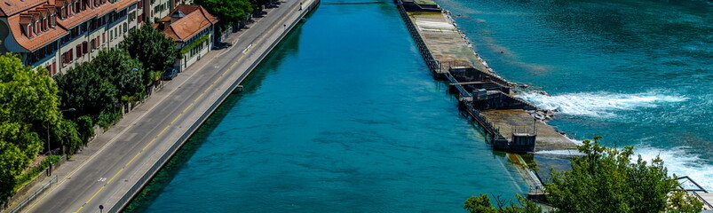 Floodgates or flood locks on the river Aare in Bern, Switzerland to regulate the water flow. There are historic residential houses built along the riverbank.