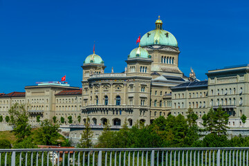 Fototapeta na wymiar BERN, SWITZERLAND - August 2nd 2022: View on The Federal Palace of Switzerland (Bundeshaus) from the Kirchenfeld Bridge.
