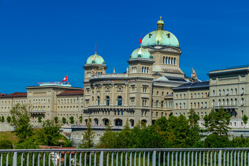 Fototapeta premium BERN, SWITZERLAND - August 2nd 2022: The Federal Palace of Switzerland (Bundeshaus) and River Aare in a beautiful summer day, Switzerland.