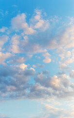 Obraz premium White clouds in the blue sky illuminated by the evening sun