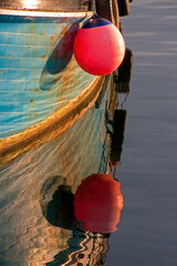 wooden fishing boat with red fender