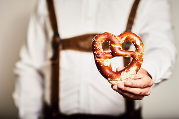 Mann in Oktoberfest Tracht in Brezel