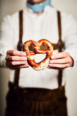 Mann in Oktoberfest Tracht in Brezel