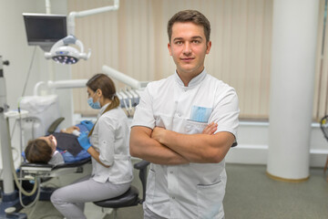 Dentist on the background of the office and treating a patient for caries and installing braces