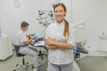 Female dentist at the dentistry office and treating a patient for caries and installing braces and artificial teeth