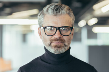 Fototapeta premium Close up photo portrait of successful senior and experienced businessman, man in glasses looking at camera, serious investor banker working in office at work