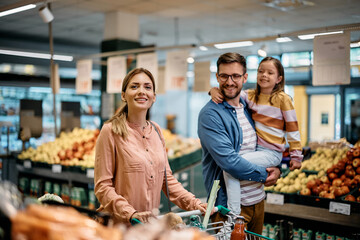 Happy family enjoys in shopping at supermarket.