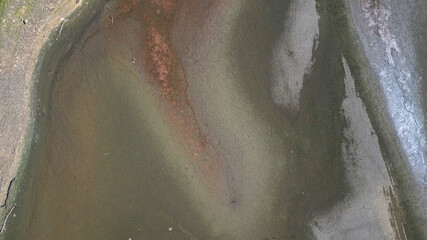 Drone footage of aerial view over Lindley Wood Reservoir, North Yorkshire, during drought in summer 2022 heatwave. Empty reservoir basin shows cracked dry bare ground.