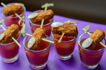 Bloody Mary cocktails in the shots drink served with Halloween bloody fingers, pork cocktail sausages decorated with flaked almonds