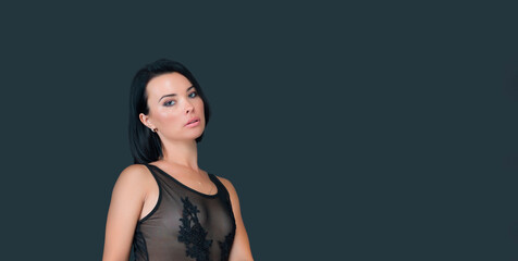 Fototapeta premium Beautiful young woman with healthy luxurious black hair and clear skin on gray banner background with space for text. Hairstyle, skincare. Sensual caucasian model brunette woman looking at camera.