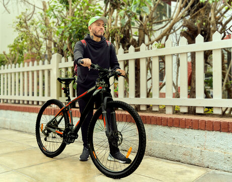 Young Gay Man Holding His Bicycle On A Lima Street