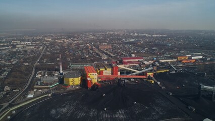 Factory for processing coal on background of city. City-forming enterprise. Drone view