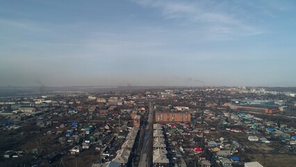 Panorama of polar city in Russia. Low-rise buildings against backdrop of smoking chimneys of industrial enterprises