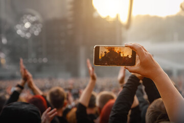 Smartphone in the hand of a music fan at the summer concert.