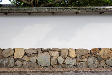 石垣と白壁と屋根で構成された日本の伝統的な塀