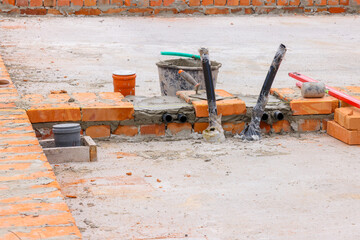 initial rows of brickwork. the initial stage of building a house. masonry of orange ceramic bricks.