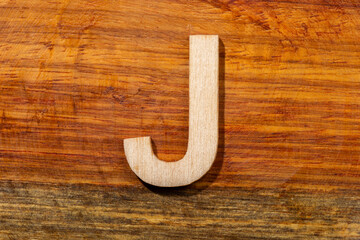 Wooden letters J on wooden background