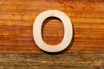 Wooden letters O on wooden background, top view