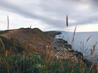 Ocean view and cliffs off Cape Breton, Nova Scotia. Cabot Trail visible in the background