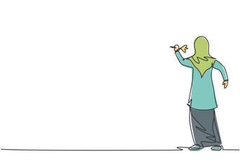 Continuous one line drawing young Arab female worker focus to hit target with a dart precise. Business goal management minimalist concept. Single line draw design vector graphic illustration.