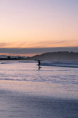 sunset on the beach with surfer