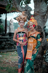 Two beautiful girls in the temple. Dressed in old traditional costume, edited color.