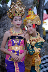 Two beautiful girls in the temple. Dressed in old traditional colorful costume.