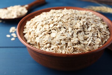 Bowl of oatmeal on blue wooden table, closeup