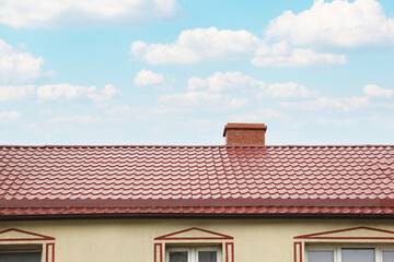 Beautiful house with red roof against blue sky, low angle view