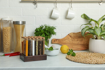 Glass tubes with different spices on kitchen counter