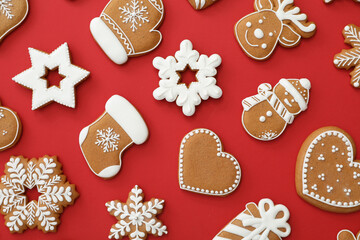 Different Christmas gingerbread cookies on red background, flat lay