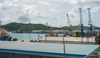 Industrial port crane lift up loading export containers box onboard at port of Thailand.