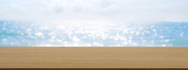 Empty Wood Table on Sea Summer Background.Blank desk with bokeh water ocean and blue sky Horizon Landscape Outdoor photo backdrop.Mockup Board for add Product Presentation.Tropical Nature Tourism.
