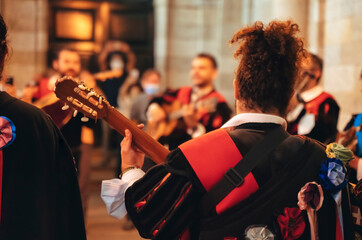  Tuna Music of Santiago - Band of University students musicians, dressed in academic costume, playing and singing serenades. on a Santiago de Compostela city street, Galicia, Spain - obrazy, fototapety, plakaty