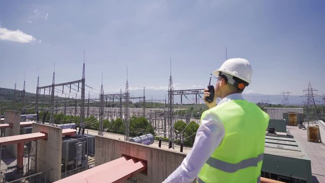 Power generation plant and switchyard.
The engineer works at the switchboard and talks to his colleague over the radio.
