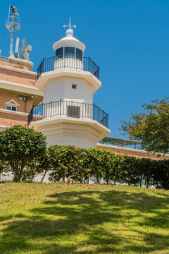 White lighthouse in front of building in visitor complex in Ulsan, South Korea.