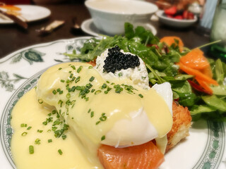 Delicious eggs Benedict with hollandaise sauce and caviar 