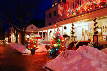 Beautiful and colorful Christmas lights and decorations brighten a New England snowy winter night at a historic inn