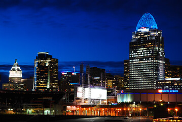 Naklejka premium As dusk settles, the lights of the Cincinnati city skyline illuminates and is reflected in the waters of the Ohio River