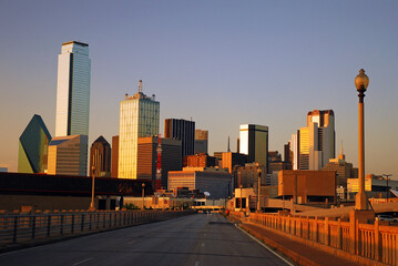 The Dallas Skyline towers over the Commerce Street Bridge and reflects the setting sun in the...