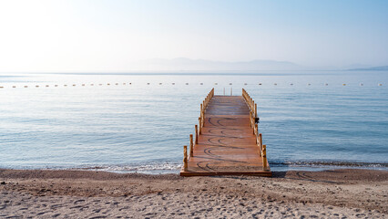 wooden pier on the sea shore, front view. Aspat Bay