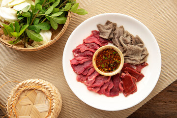 raw food ingredient. thai local food  menu soi ju, sajin, Laab, koy,soy ju , raw meat with sauce over dish on table background. 