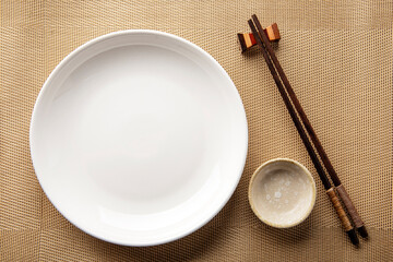 ceramic set blank dish (plate) and chopsticks on table
