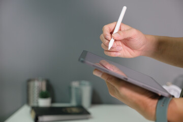 Close-up of a young businessman working on wear suit touch tablet pen.architect design in the office