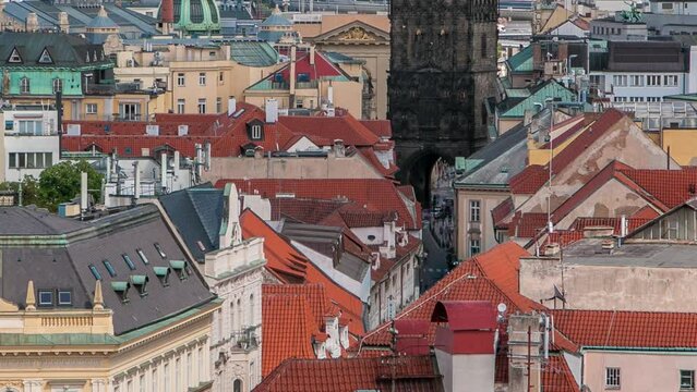 Aerial view of the traditional red roofs of the city of Prague, Czech Republic with the Powder tower and Vitkov Hill in the distance timelapse. Top view from Old Town Hall tower
