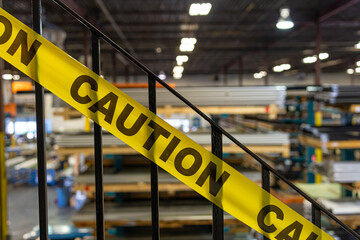 Yellow caution tape on stair metal handrails