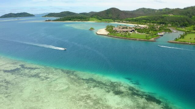 Aerial Forward Shot Of Speedboat Moving On Rippled Ocean By Island - Suva, Fiji