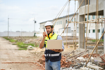 Fototapeta na wymiar Foreman order to team with walkie talkie by spec on laptop on construction site